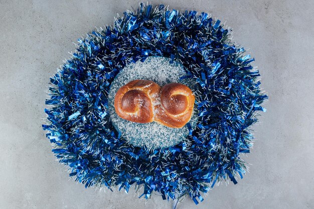 Girlandenkreis mit einem Brötchen in der Mitte auf Marmor