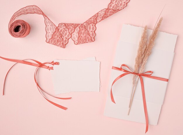 Girly Anordnung der flachen Lage für Hochzeitseinladungen auf rosa Hintergrund