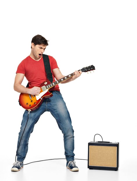 Gitarrist Mann spielt auf der E-Gitarre mit hellen Emotionen, isoliert auf weißer Wand