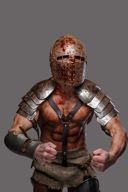 Kostenloses Foto gladiator im helm mit muskulösem körper zeigt seine stärke