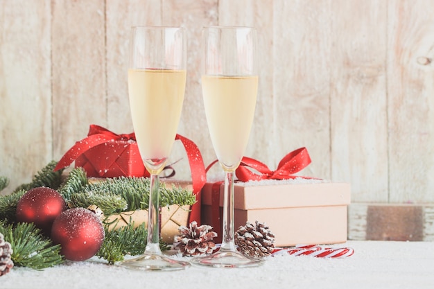 Gläser Champagner mit Geschenken und Weihnachtsschmuck