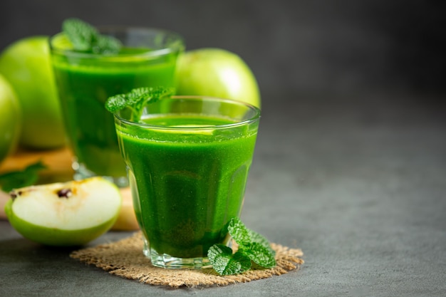 Gläser mit gesundem Smoothie aus grünem Apfel neben frische grüne Äpfel