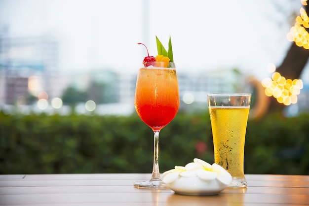 Gläser mit kühlem Bier und Mai Tai oder Mai Thai weltweit bevorzugen einen Cocktail in der Dämmerung