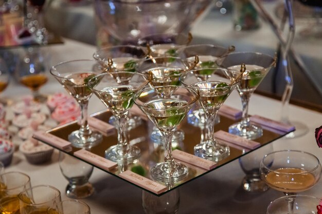 Gläser mit Martini und grünen Oliven stehen auf Spiegelablage