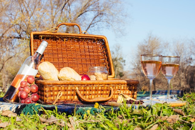 Gläser Wein neben Picknickkorb