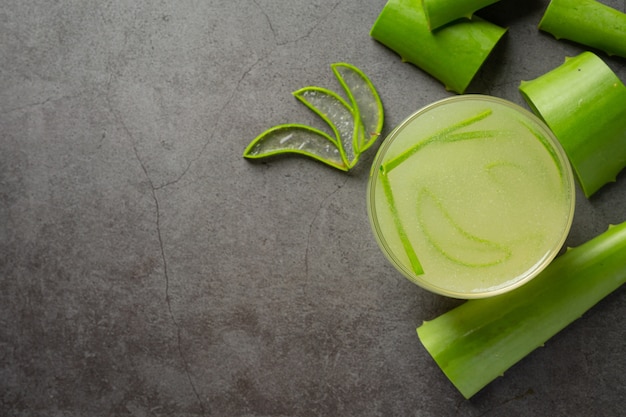 Glas Aloe Vera Saft auf dunklen Boden gestellt