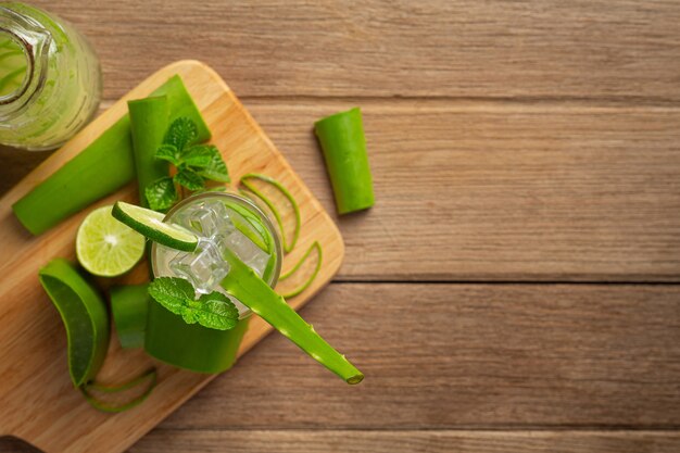 Glas Aloe Vera Saft auf Holzschneidebrett setzen