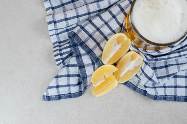 Glas Bier mit Zitronenscheiben auf Tischdecke