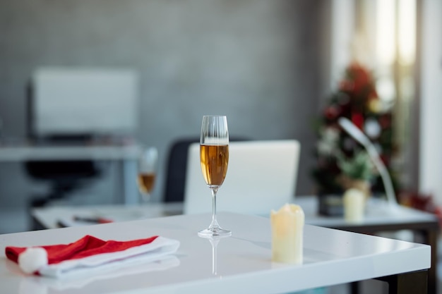 Glas Champagner auf dem Bürotisch während der Weihnachtsferien