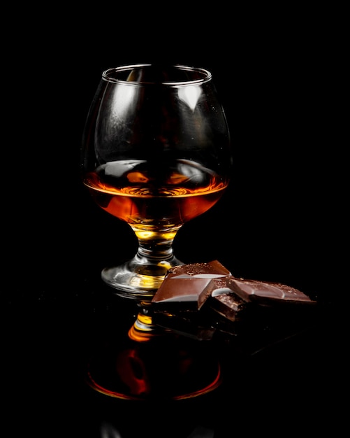 Glas Cognac und dunkle Schokolade
