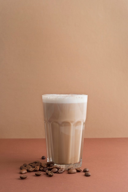 Glas Frappekaffee mit Kaffeebohnen daneben