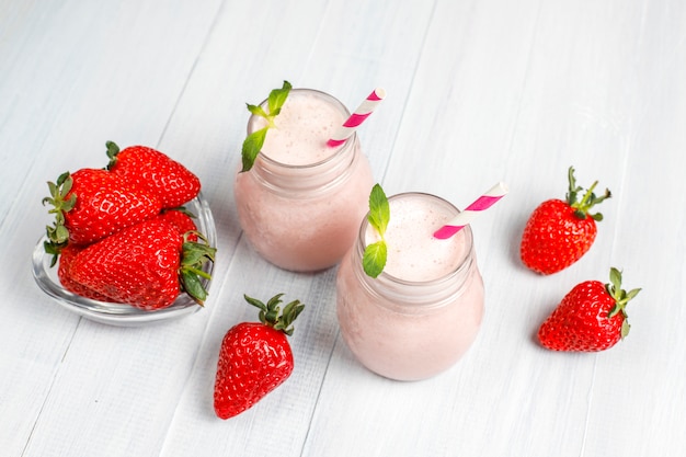 Glas frischer Erdbeermilchshake, Smoothie und frische Erdbeeren, gesundes Lebensmittel- und Getränkekonzept.