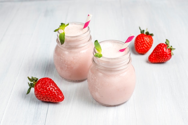 Glas frischer Erdbeermilchshake, Smoothie und frische Erdbeeren, gesundes Lebensmittel- und Getränkekonzept.