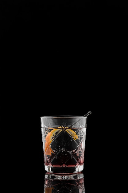 Glas Getränk mit Orangenscheibe in der Dunkelheit