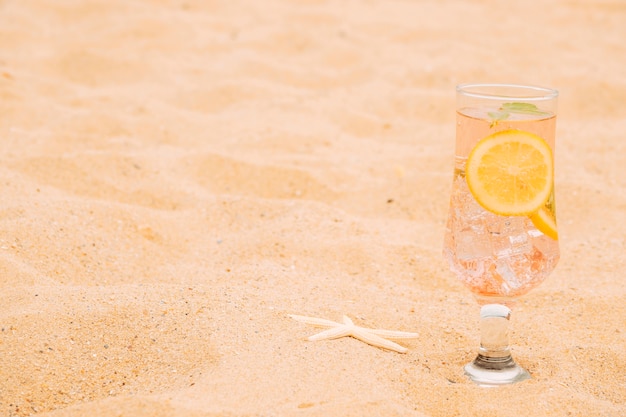 Glas kühles Getränk mit geschnittener Zitrusfrucht und Starfish