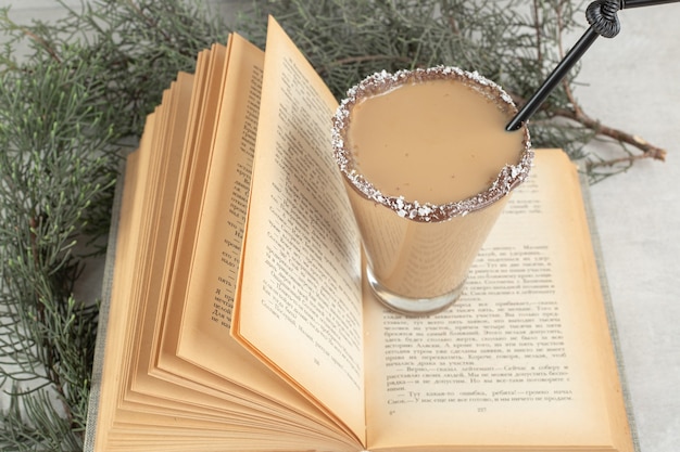 Glas leckeren Kaffee auf offenem Buch