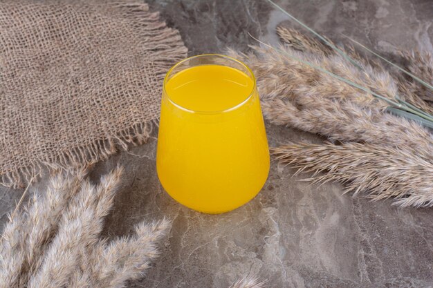 Glas Limonade mit Ähren auf Marmortisch