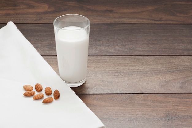 Glas Mandelmilch auf hölzernem Hintergrund