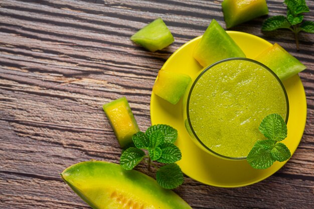 Glas Melonensaft auf Holzboden gestellt