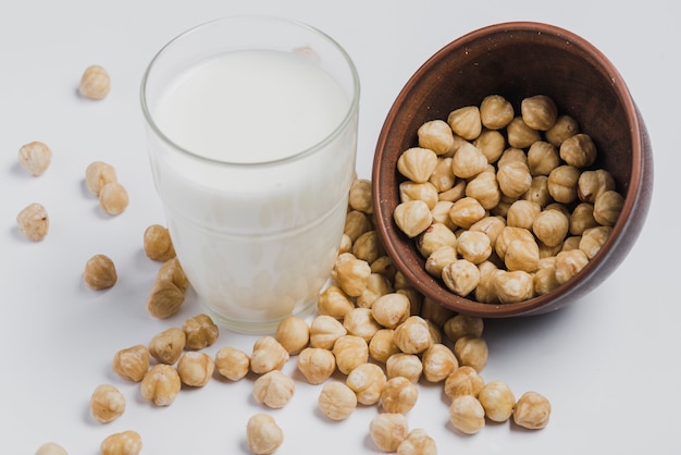 Glas Milch in der Nähe von Haselnüssen