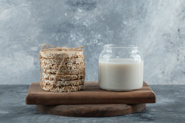 Glas Milch mit leckerem Knäckebrot auf Holzbrett