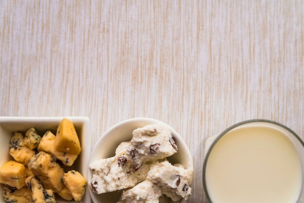 Glas Milch nahe Platten mit geschmackvollem Käse