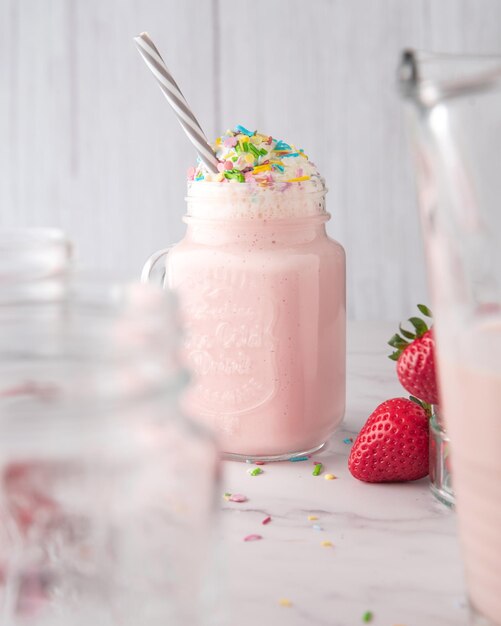 Glas mit einem Erdbeer-Erfrischungsgetränk mit verschiedenen Zuckerstreuseln