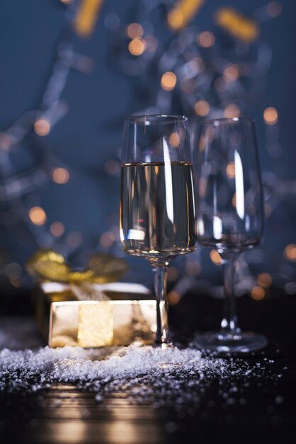 Glas mit Getränk an Bord in der Nähe von Ornament Schnee und Präsentkarton