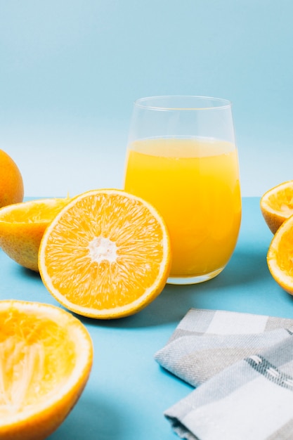 Glas mit Orangensaft auf blauem Hintergrund