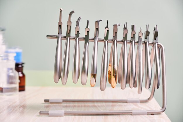 Glas mit Watterollen und kieferorthopädischen Instrumenten für zahnärztliche Eingriffe