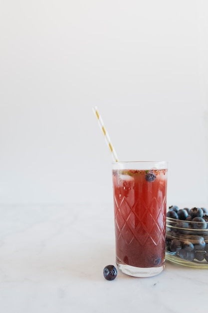 Glas nahe Schüssel mit Blaubeeren