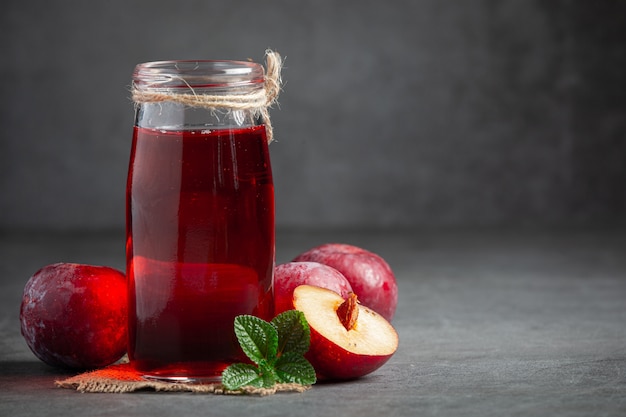 Glas Pflaume auf dunklen Boden gestellt