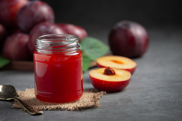 Glas Pflaume auf dunklen Boden gestellt