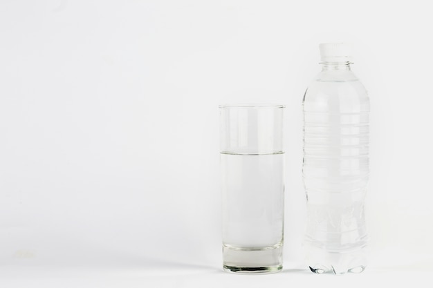 Glas und Flasche mit klarem Wasser