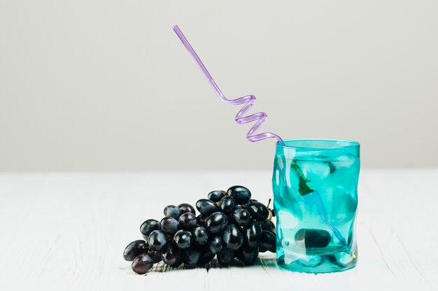 Glas Wasser und Trauben auf normalem Hintergrund