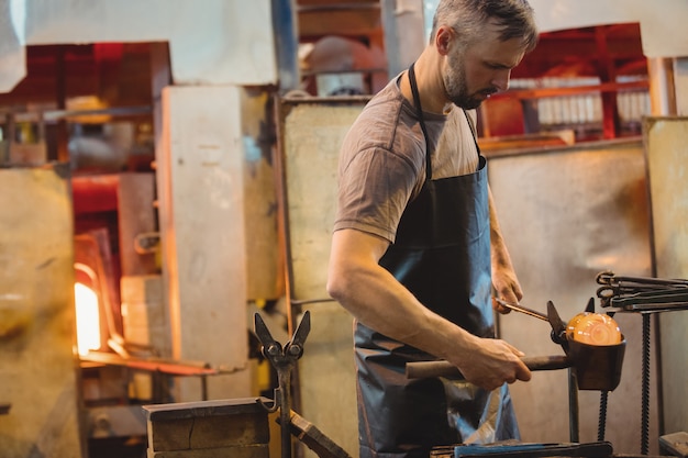 Glasbläser, der ein geschmolzenes Glas bildet und formt