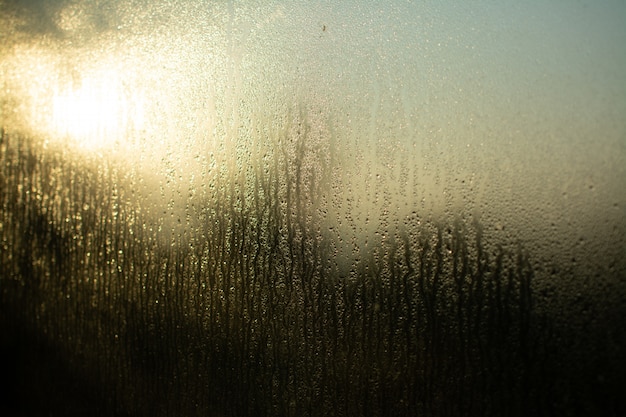 Glasfenster reflektiert Licht durch seine nasse Textur