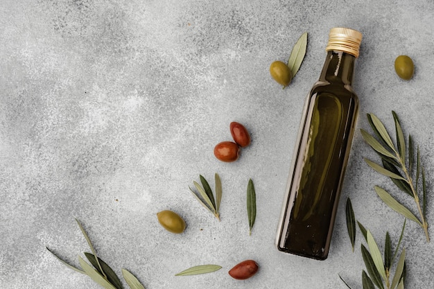 Glasflasche mit olivenöl auf grauem hintergrund