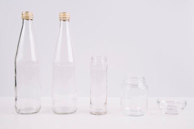 Glasflaschen und Cup auf weißem Hintergrund