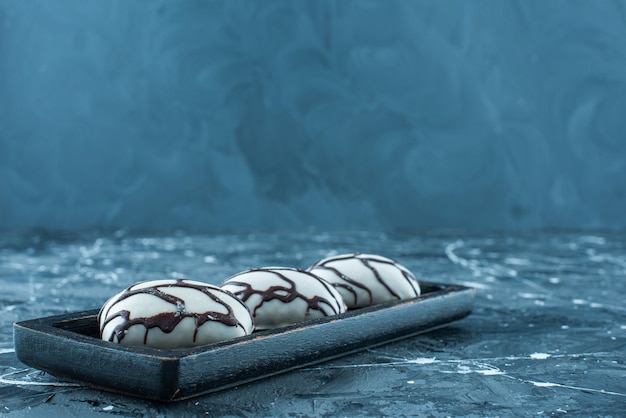 Glasierte Bonbons auf einem Tablett, auf dem blauen Tisch.