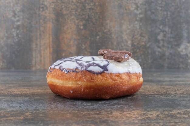 Glasierter Donut und ein Tannenzweig auf Marmoroberfläche