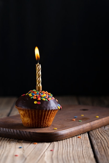 Glasierter kleiner Kuchen mit brennender Kerze