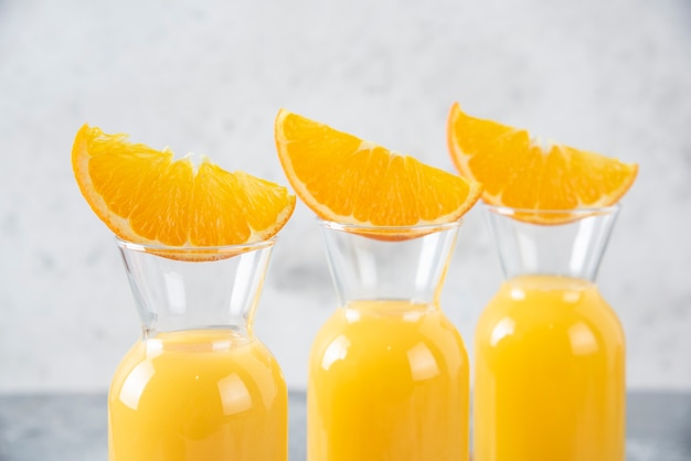 Kostenloses Foto glaskrüge saft mit scheiben von orangenfrüchten auf ein hölzernes schneidebrett gelegt.