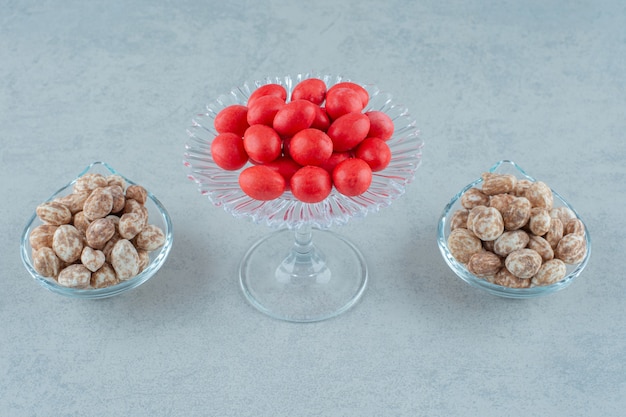 Kostenloses Foto glasteller voller leckerer lebkuchen und roter süßer bonbons auf weißer oberfläche