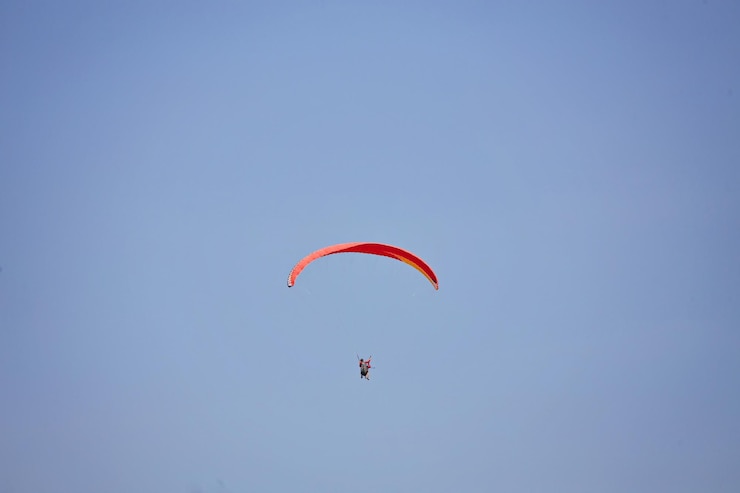 Kostenlose Foto gleitschirmfliegen am himmel gleitschirmfliegen in hellem, sonnigem tag schöne gleitschirmflieger im flug auf türkisfarbenem hintergrund