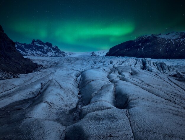 Gletscher in der Nacht mit einer Aurora Borealis am Himmel.