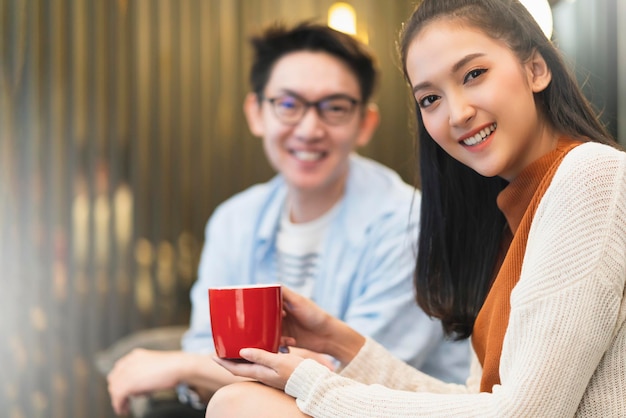 Glück junges asiatisches Paar heiraten Familie genießen TV-Show und gute Gespräche umarmen sich zusammen Hand halten Kaffee trinken lachen Lächeln zusammen auf der Sofacouch im Wohnzimmer nach Hause Innenhintergrund