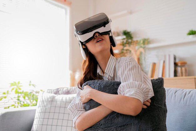 Glück verließ asiatische weibliche Teenager-Handwelle zusammen mit ihrer virtuellen Konzertaufführung über virtuelles Goggle virtuelles interaktives Headsetasia Frau bleibt zu Hause Innovation Technologie Lifestyle vr zu Hause