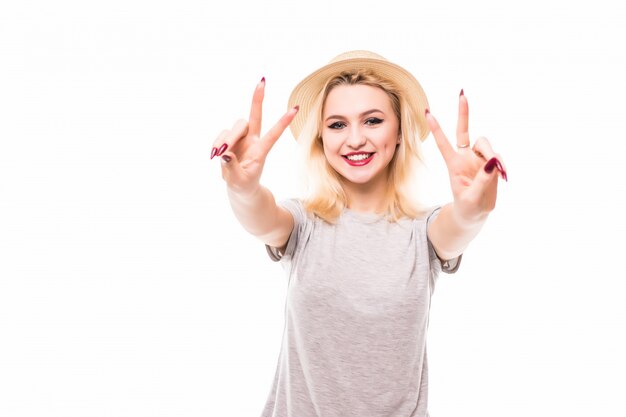 Glücklich lächelnde schöne junge Frau, die zwei Finger oder Siegesgeste zeigt