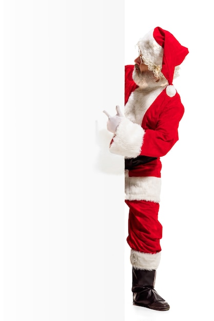 Kostenloses Foto glücklich überrascht weihnachtsmann zeigt auf leer